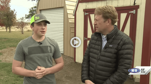 Two men standing in front of a shed.